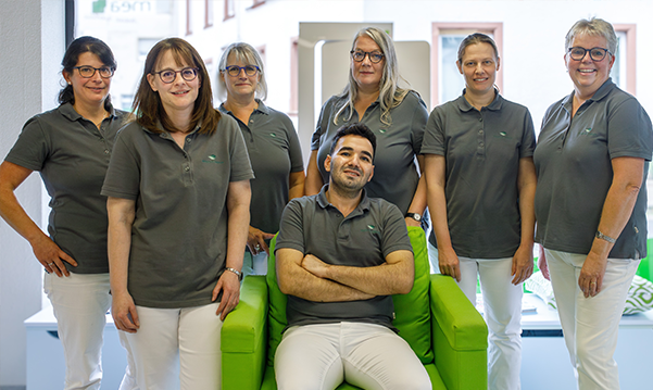 Das Team der Martinus Apotheke in Trier steht un den sitzenden Inhaber der Apotheke.