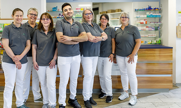 Das Apothekenteam steht vor dem Tresen in der Martinus Apotheke.